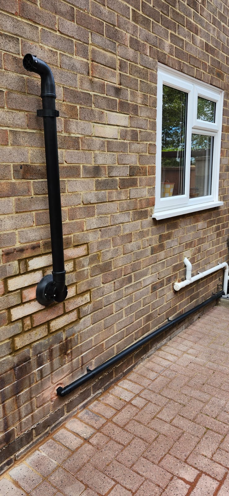 External boiler flue with plume management kit and condensate pipework on a brick wall in Gillingham